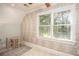 Bright bedroom features a cozy sitting area and a large window at 395 Grove Ridge Dr, Loganville, GA 30052