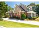 Stately brick home with a side-entry garage, manicured landscaping, and timeless elegance at 395 Grove Ridge Dr, Loganville, GA 30052
