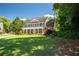 Beautiful traditional home featuring a lush green lawn, mature trees, and brick facade at 395 Grove Ridge Dr, Loganville, GA 30052