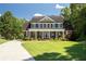 Charming brick home with a columned front porch and well-manicured lawn, offering classic curb appeal at 395 Grove Ridge Dr, Loganville, GA 30052