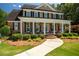 Inviting brick home with a columned front porch and meticulously landscaped yard, offering curb appeal at 395 Grove Ridge Dr, Loganville, GA 30052