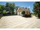 Two-car garage with brick siding and ample driveway space, framed by mature trees and a basketball hoop at 395 Grove Ridge Dr, Loganville, GA 30052