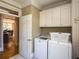 Functional laundry room equipped with a washer, dryer, and overhead cabinets for storage at 395 Grove Ridge Dr, Loganville, GA 30052