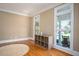 Cozy living room featuring hardwood floors, large windows, and a built-in shelving unit at 395 Grove Ridge Dr, Loganville, GA 30052