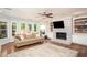 Cozy living room featuring a brick fireplace and built-in bookshelves at 395 Grove Ridge Dr, Loganville, GA 30052