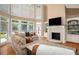 Spacious living room featuring a fireplace, large windows, and comfortable seating at 395 Grove Ridge Dr, Loganville, GA 30052