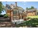 View of the rear exterior with a brick facade, covered patio, deck, and manicured landscaping at 395 Grove Ridge Dr, Loganville, GA 30052