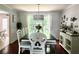 Formal dining room featuring a large table and chairs, with view to outdoor space at 627 Arbour Way, Suwanee, GA 30024