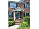 Charming brick home's front door with black shutters and lush manicured front yard at 627 Arbour Way, Suwanee, GA 30024