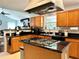 Spacious kitchen with black counters, island cooktop, and wooden cabinets at 627 Arbour Way, Suwanee, GA 30024