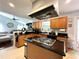 Spacious kitchen with black countertops, island cooktop, and oak cabinetry at 627 Arbour Way, Suwanee, GA 30024