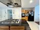 Kitchen island with cooktop, adjacent to stainless steel appliances and a white-tile floor at 627 Arbour Way, Suwanee, GA 30024