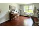 Cozy living room features a piano, a window seat and hardwood floors at 627 Arbour Way, Suwanee, GA 30024