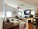 Sunlit living room features a vaulted ceiling, plush sectional, and fireplace at 627 Arbour Way, Suwanee, GA 30024
