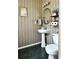 Stylish powder room featuring patterned wallpaper and a pedestal sink at 627 Arbour Way, Suwanee, GA 30024