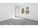 Sunlit bedroom with gray carpet and view of greenery at 1517 Ellie Ridge Ave, Lawrenceville, GA 30043