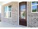 Close-up of a stylish front door with glass panels, flanked by bright, modern windows at 1517 Ellie Ridge Ave, Lawrenceville, GA 30043