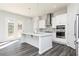 Open concept kitchen with stainless appliances, kitchen island with seating and wood flooring at 1517 Ellie Ridge Ave, Lawrenceville, GA 30043