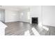 An open-concept living room with a fireplace and modern gray wood flooring at 1517 Ellie Ridge Ave, Lawrenceville, GA 30043