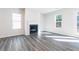 Cozy living room with a fireplace, gray floors, and natural lighting at 1517 Ellie Ridge Ave, Lawrenceville, GA 30043