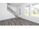 Bright living room with modern gray wood flooring, large windows, and white trim at 1517 Ellie Ridge Ave, Lawrenceville, GA 30043