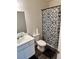 Well-lit bathroom featuring a vanity, toilet, and a bathtub with a decorative patterned shower curtain at 536 Magnolia Cir # 116, Palmetto, GA 30268