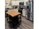 Modern kitchen featuring stainless steel appliances, white cabinetry, and a butcher block island with seating at 536 Magnolia Cir # 116, Palmetto, GA 30268
