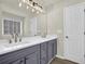 Bathroom with a double sink vanity featuring gray cabinets and white countertop next to a white door at 6341 Stewart Ridge Walk, Buford, GA 30518
