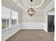 Dining room featuring hardwood floors, neutral paint, a modern light fixture, and a view into the kitchen area at 6341 Stewart Ridge Walk, Buford, GA 30518