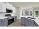 Charming kitchen boasts stainless steel appliances, white and gray cabinets, and ample lighting at 6341 Stewart Ridge Walk, Buford, GA 30518