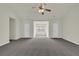 Spacious carpeted living room with neutral walls, ceiling fan, and multiple doorways at 6341 Stewart Ridge Walk, Buford, GA 30518