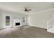 The living room features hardwood floors, neutral paint, a fireplace, a ceiling fan, stairs, and a glass paned exterior door at 6341 Stewart Ridge Walk, Buford, GA 30518