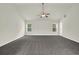 Expansive living room with plush carpet, neutral walls, ceiling fan, and large windows at 6341 Stewart Ridge Walk, Buford, GA 30518