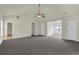 Large living room featuring plush carpet, neutral walls, ceiling fan, and multiple doorways at 6341 Stewart Ridge Walk, Buford, GA 30518
