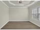 This room features hardwood floors, a decorative tray ceiling, neutral paint, white trim, and lots of natural light at 6341 Stewart Ridge Walk, Buford, GA 30518