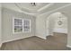 This room features hardwood floors, a tray ceiling, arched doorways, and neutral paint, with an elegant and modern style at 6341 Stewart Ridge Walk, Buford, GA 30518