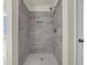 Walk-in shower with gray marble-look tile and a built-in niche for toiletries at 6341 Stewart Ridge Walk, Buford, GA 30518