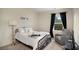 Serene bedroom with a metal frame bed, neutral decor, and a gray rocking chair at 105 Paulowina Cir, Mcdonough, GA 30253