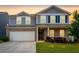 Charming two-story home featuring blue siding, brick accents, and a well-maintained front lawn at 105 Paulowina Cir, Mcdonough, GA 30253