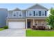 Charming two-story home featuring a brick facade, two-car garage, and beautifully landscaped front yard at 105 Paulowina Cir, Mcdonough, GA 30253