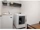 Efficient laundry room with white appliances, a shelf, and stylish tile flooring at 105 Paulowina Cir, Mcdonough, GA 30253