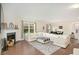 Bright living room with a fireplace, large sectional sofa, and hardwood floors at 105 Paulowina Cir, Mcdonough, GA 30253