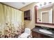 Bathroom featuring a vanity with dark wood cabinets, a black countertop, and a shower with tub at 130 Nicki Ct, Hampton, GA 30228