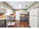 Spacious kitchen featuring stainless appliances, dark hardwood floors, light colored walls and granite countertops at 130 Nicki Ct, Hampton, GA 30228