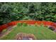 Private backyard with lush landscaping and a red fence at 204 Starwood Ct, Acworth, GA 30102