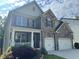 Inviting two-story home with stone accents, a charming front porch, and a two-car garage, set against a partly cloudy sky at 204 Starwood Ct, Acworth, GA 30102