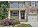 Charming front porch with decorative columns, lush landscaping, and a welcoming entrance with a wreath on the door at 204 Starwood Ct, Acworth, GA 30102