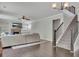 Inviting living room featuring a stone fireplace, built-in shelving, a plush sectional and staircase at 204 Starwood Ct, Acworth, GA 30102