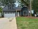 Charming home featuring a well-maintained lawn, and a paved driveway leading to an attached garage at 325 Garrison Se Dr, Marietta, GA 30060