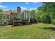 A backyard featuring a lush lawn, mature trees, and a deck with a grill, perfect for outdoor enjoyment at 4381 Laurian Nw Dr, Kennesaw, GA 30144
